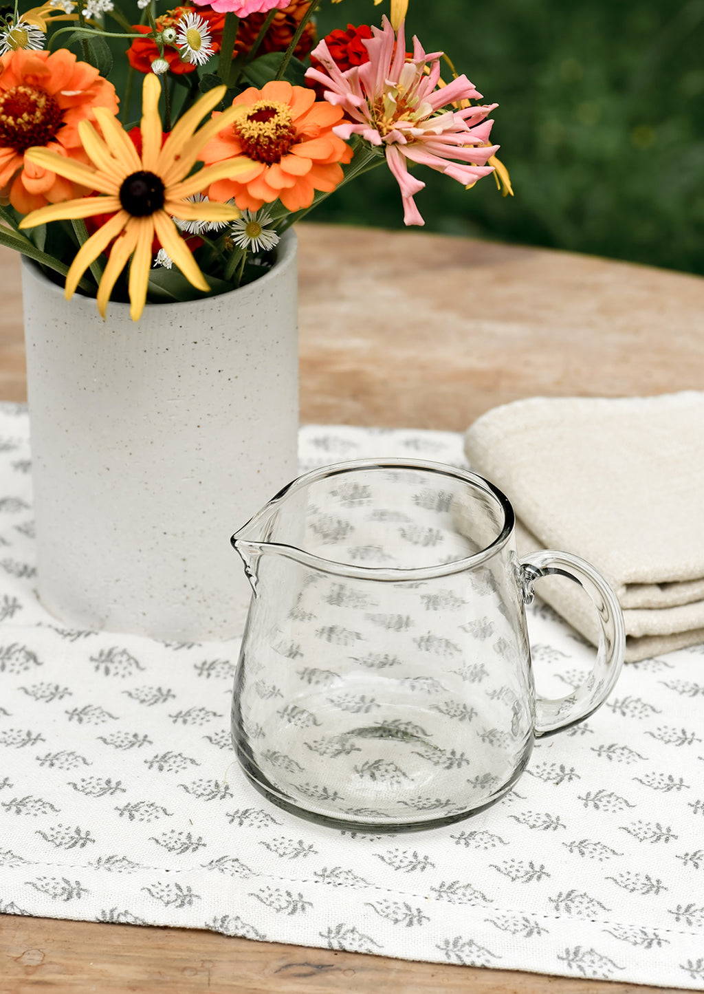 Large / 30 oz: A small clear glass pitcher on a table.