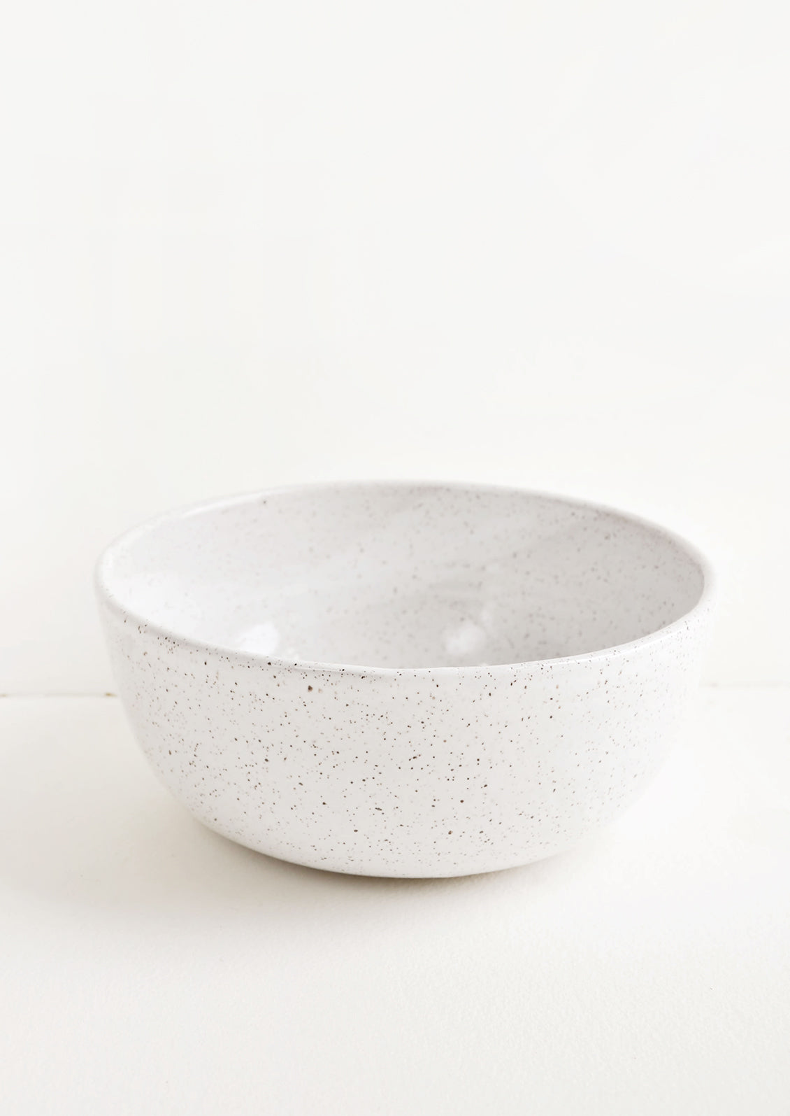 Hearty ceramic bowl, ideal for serving or mixing, in white glaze with brown speckles.