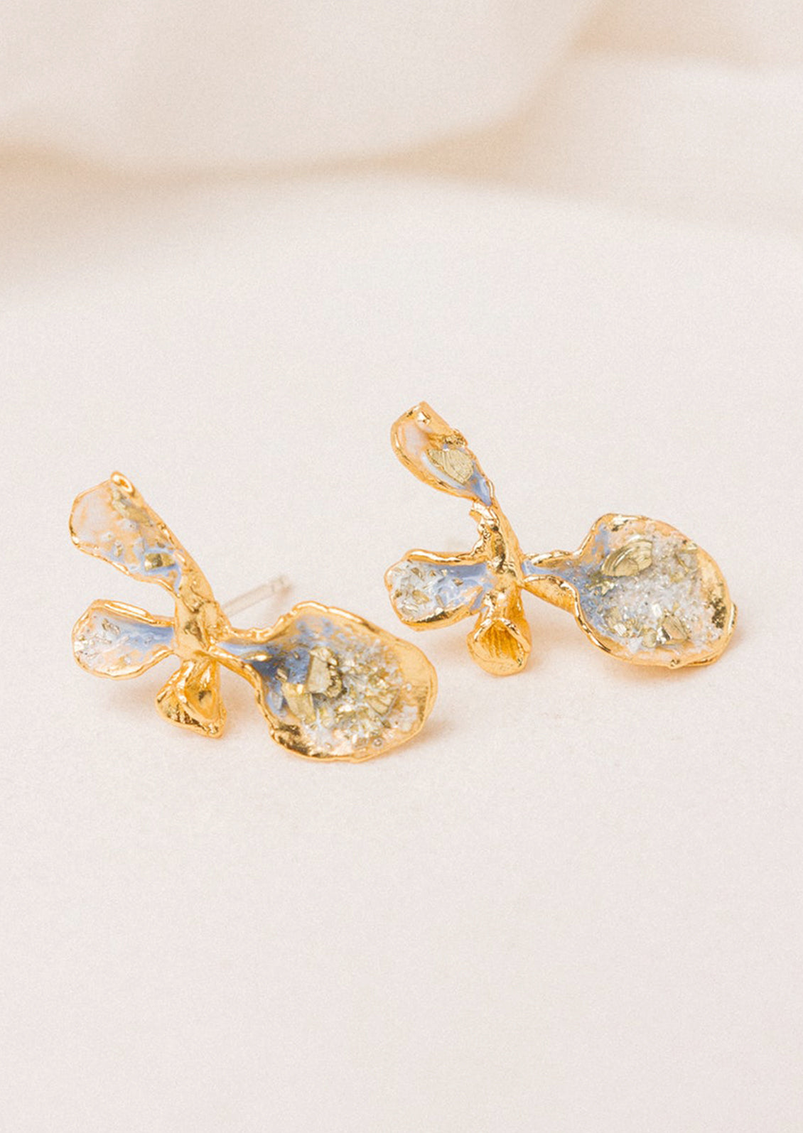 A pair of enamel painted gold earrings in shape of flower.