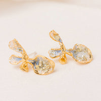 2: A pair of enamel painted gold earrings in shape of flower.