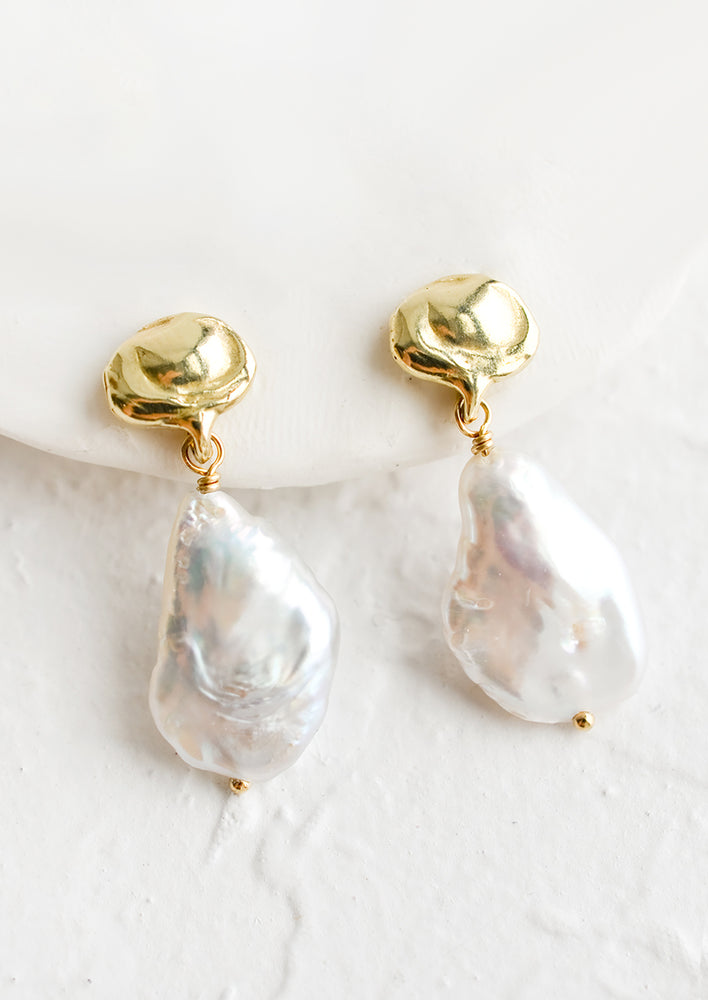 A pair of baroque pearl and brass earrings.