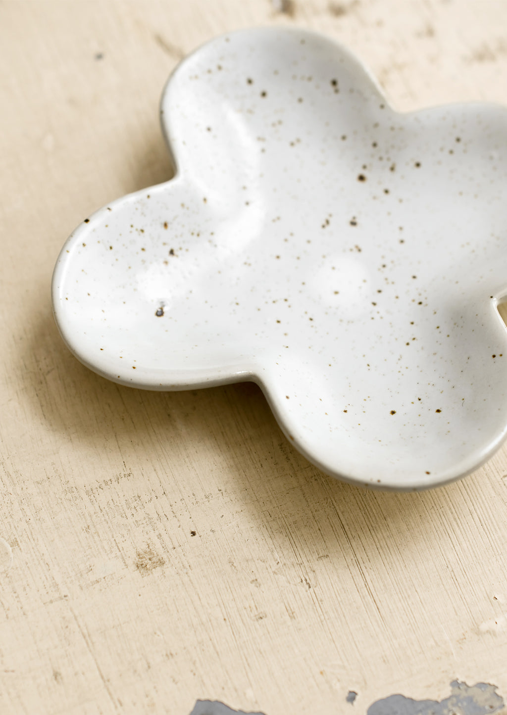 3: A clover shaped little dish in speckled white ceramic.