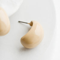 2: A pair of glossy ivory bean shaped earrings.