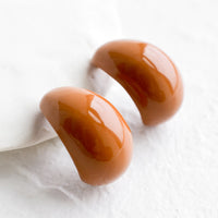 Milk Chocolate: A pair of glossy brown bean shaped earrings.