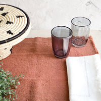 Terracotta: Table setting in earthy color palette with placemat, napkins and glass cups