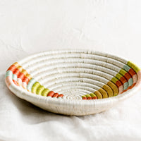 2: A woven sweetgrass bowl in white with multicolor geometric design.