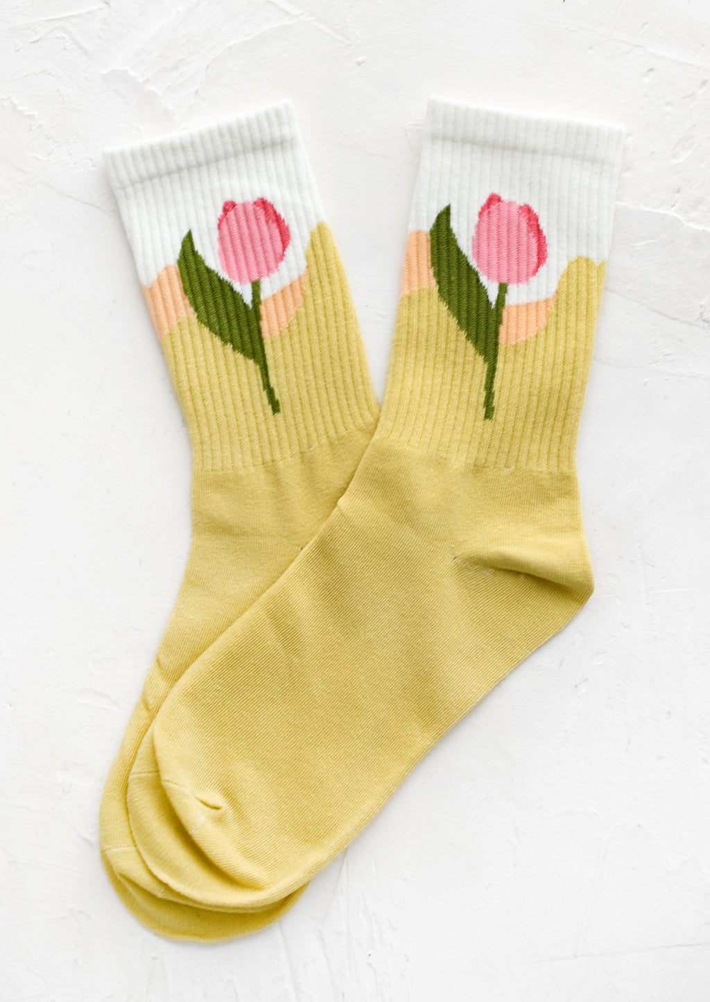Sun Yellow: A pair of socks in yellow with pink tulip design at ankle.