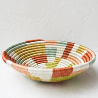 4: A large woven sweetgrass bowl in white with multicolor geometric design.