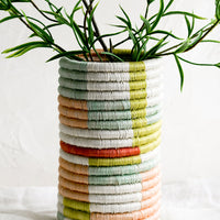 2: A woven sweetgrass vase with multicolor geometric pattern.
