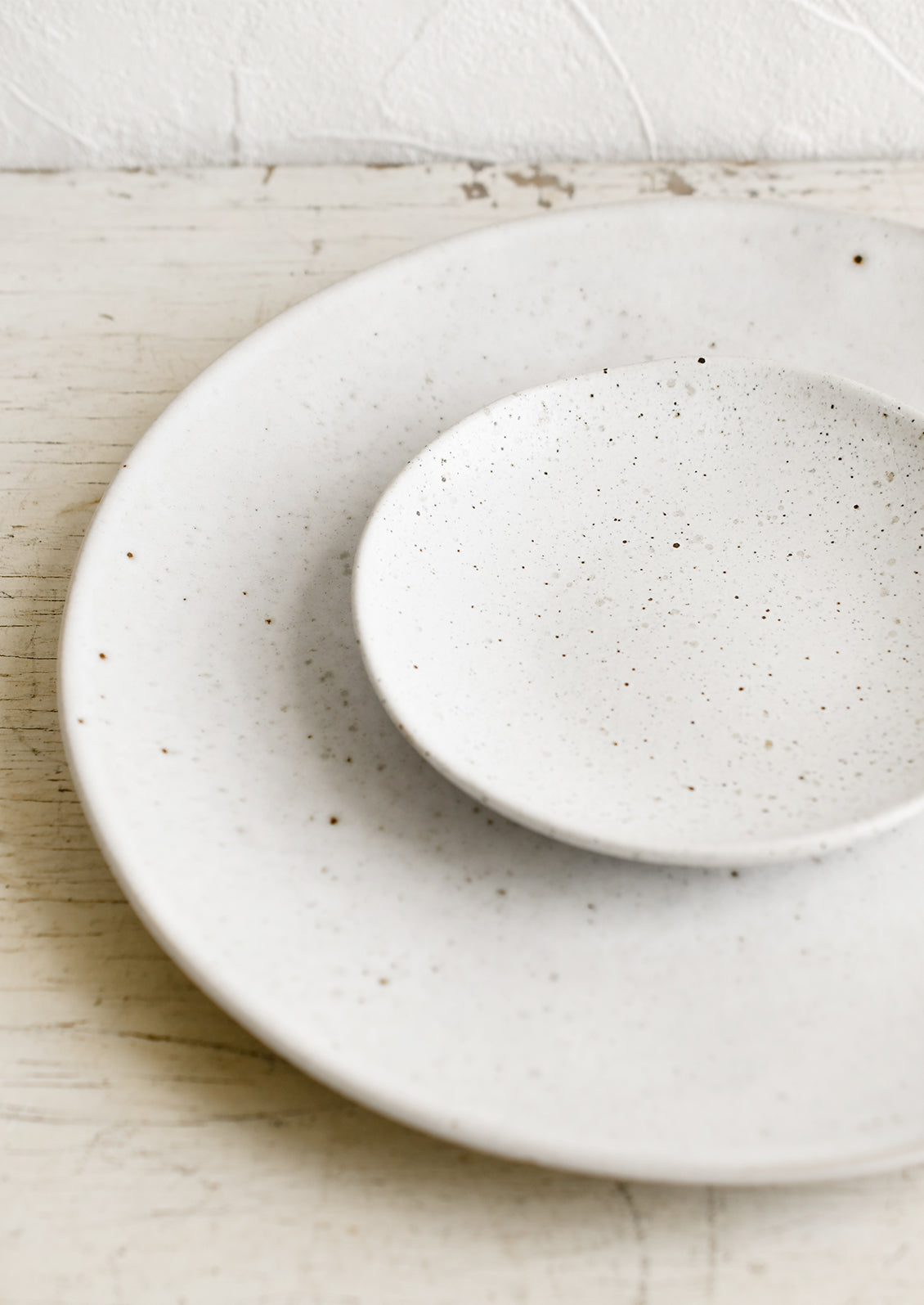 A ceramic dinner plate in natural with speckles.