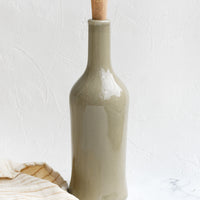 7: A glossy olive colored tall bottle with cork top
