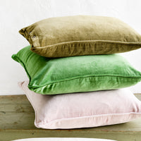 3: A stack of velvet pillows in green and pink.