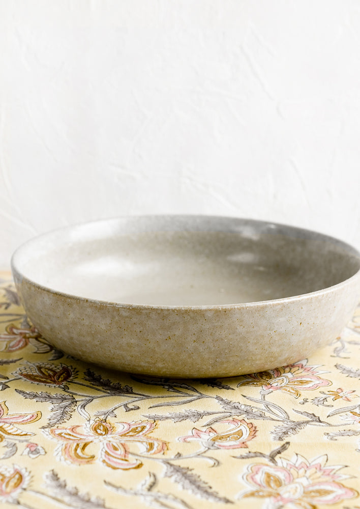 1: A low and shallow serving bowl in glazed ceramic.