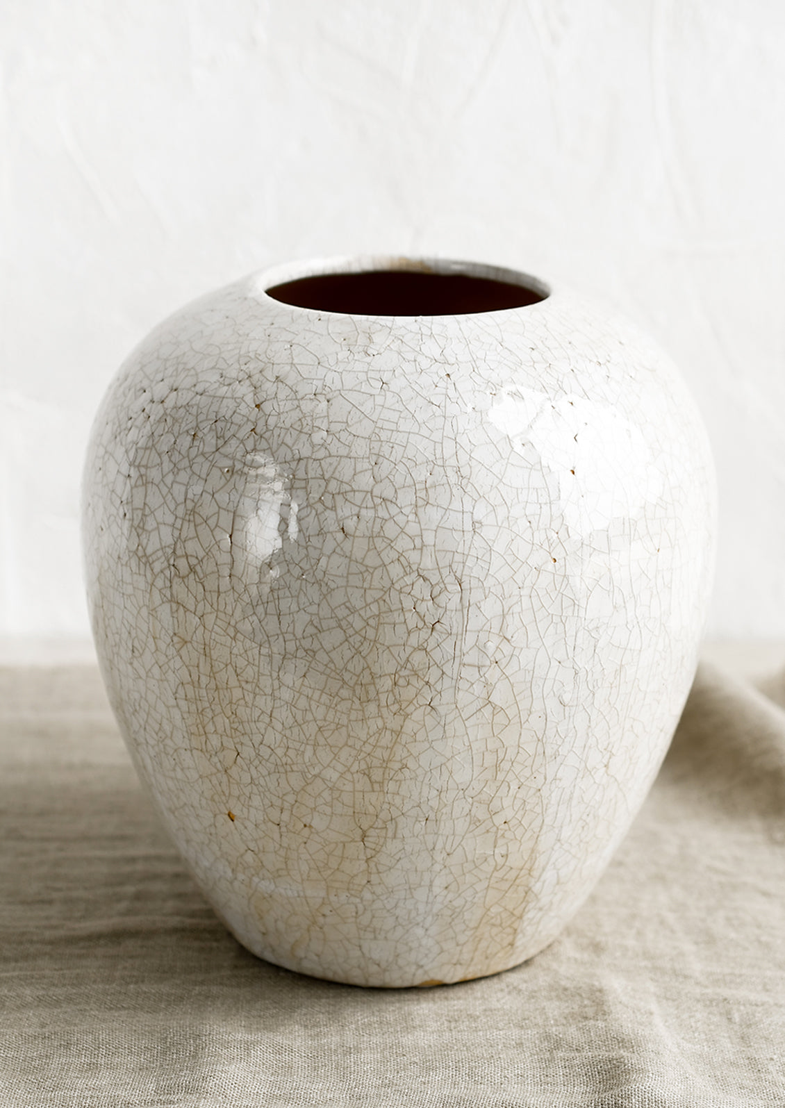 An off-white large ceramic vase with crackle pattern.