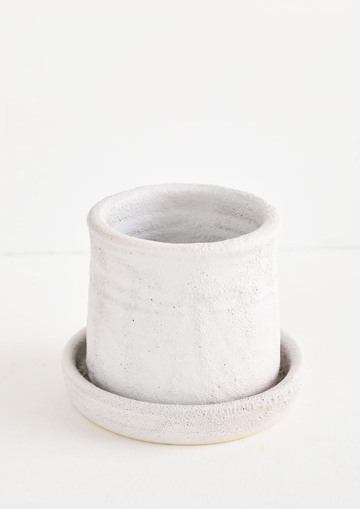 1: Round planter with saucer, allover heavy and crater-like texture in cool white matte glaze 