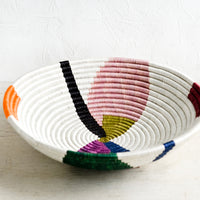 2: A large woven sweetgrass bowl in white with colorful abstract shapes.