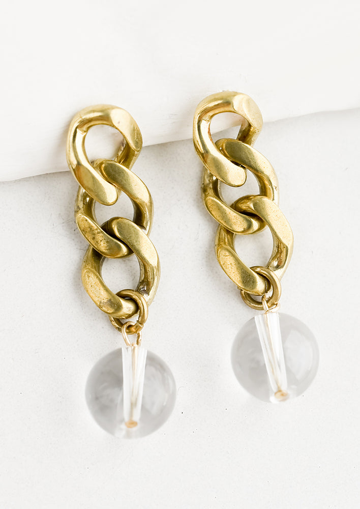 1: A pair of brass chainlink earrings with clear bead detail at bottom.