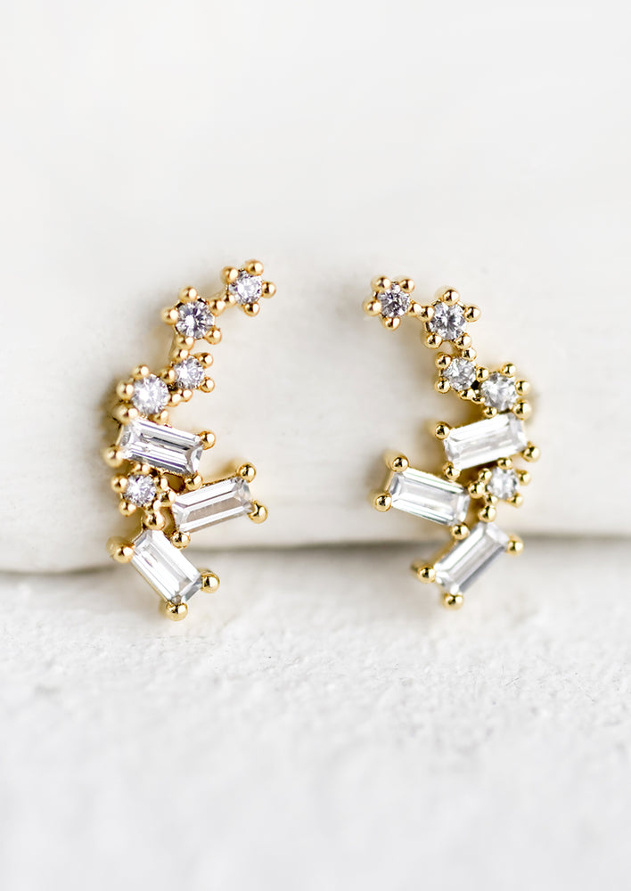 A pair of gold and crystal earrings with scattered round and rectangular crystals.