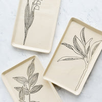 1: Rectangular ceramic trays in natural bisque color with etched black botanical drawings