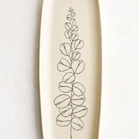 Eucalyptus: A long and skinny ceramic tray in natural bisque color with an etched black drawing of a eucalyptus branch.