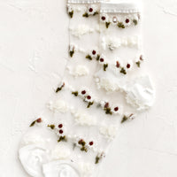 White: Sheer ankle socks with floral print and white trim.