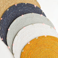 7: Five round seagrass placemats in assorted colors.