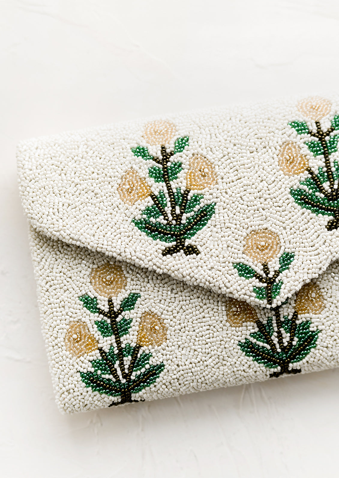 A beaded clutch in floral pattern and envelope silhouette.