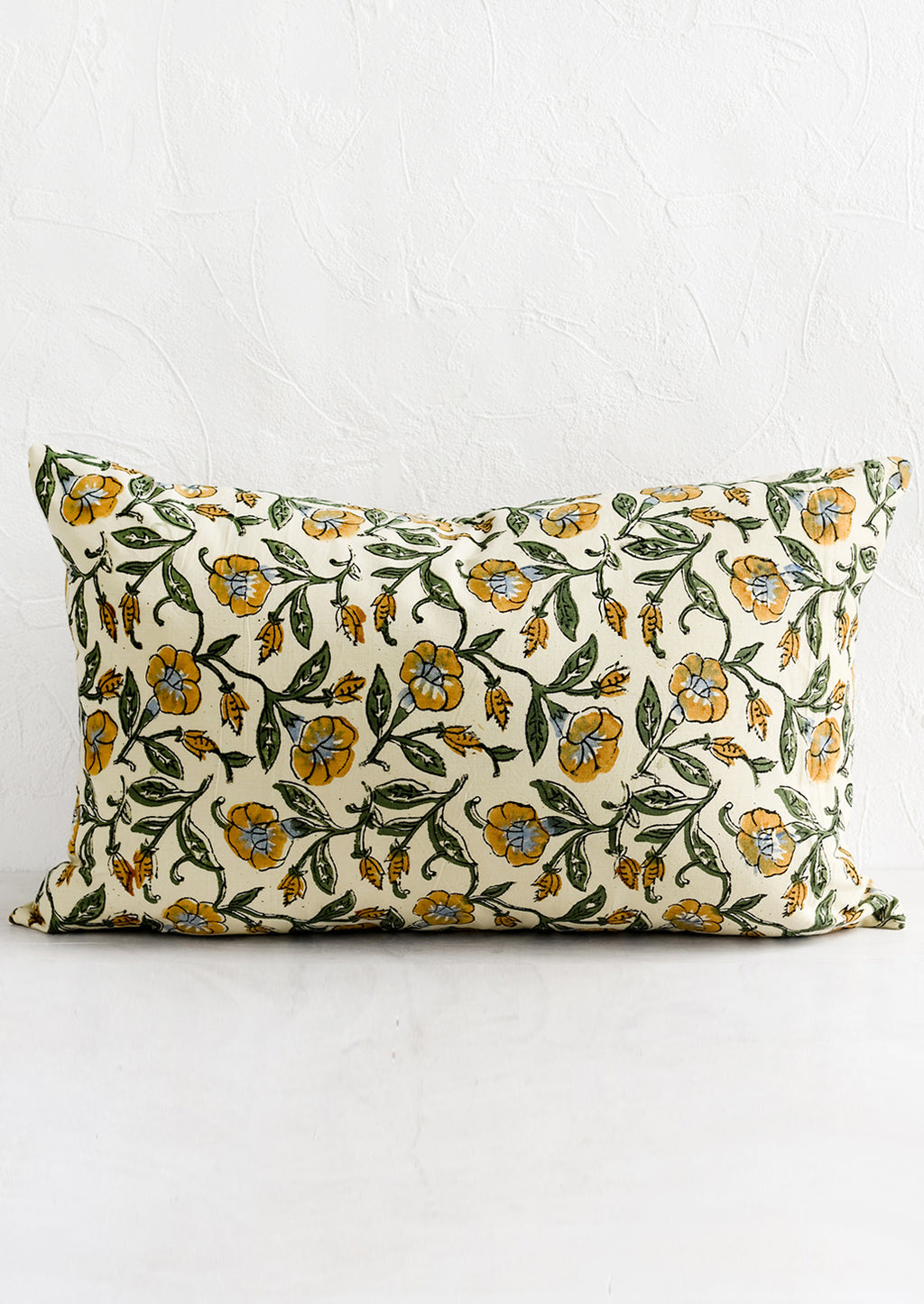 1: A lumbar pillow in beige, mustard, blue and green floral print.