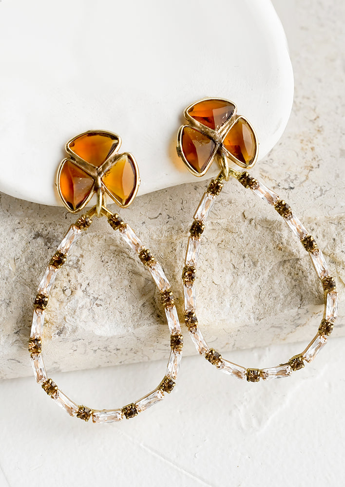 1: A pair of earrings with hollow teardrop and crystal detailing.