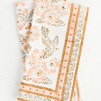2: A pair of cotton napkins with peach and brown floral print.