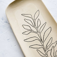7: Black etched botanical detailing on a ceramic platter.