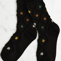 Black Multi: A pair of black socks with diamond pattern and florals.