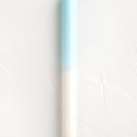 Ivory / Sky Blue: A straight taper candle in blue and white.