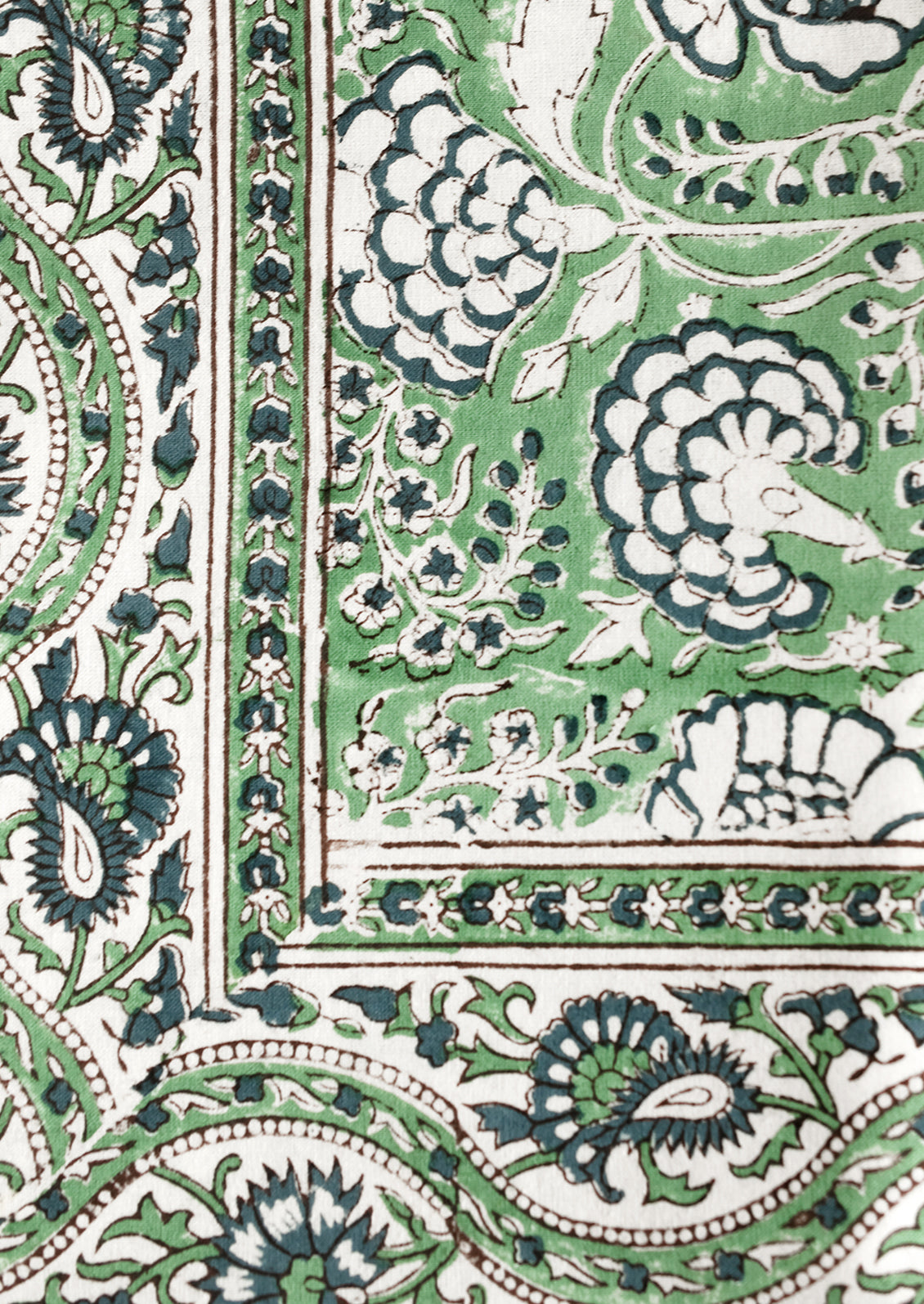 A block printed tablecloth with traditional print in blue and green shades.
