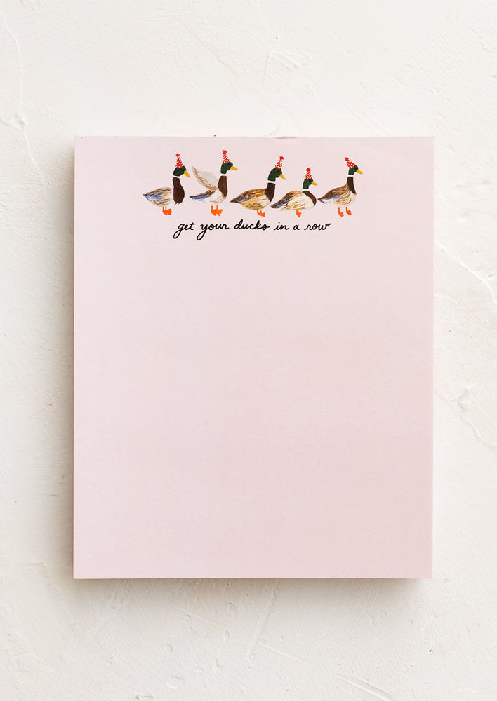 1: A pink unruled notepad with illustration of ducks in a row at top.