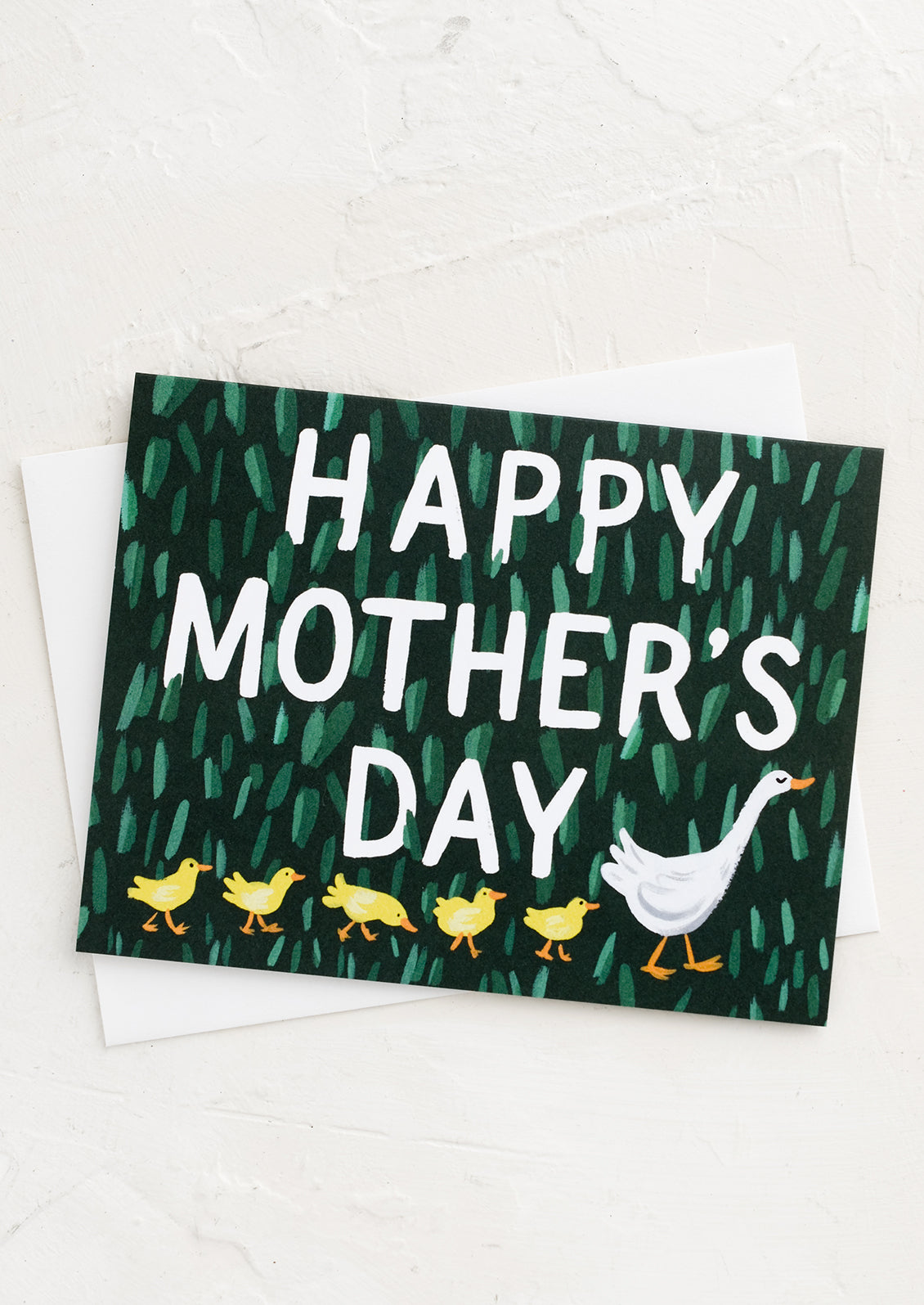 A greeting card with adult duck leading a row of baby ducks.