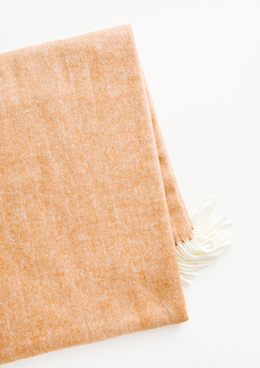 Copper: Soft blanket in copper colored herringbone weave. Ivory tassel trim at ends.