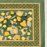 1: A block printed placemat in green and yellow fruit print.