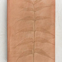1: A natural leather journal with embossed leaf design.