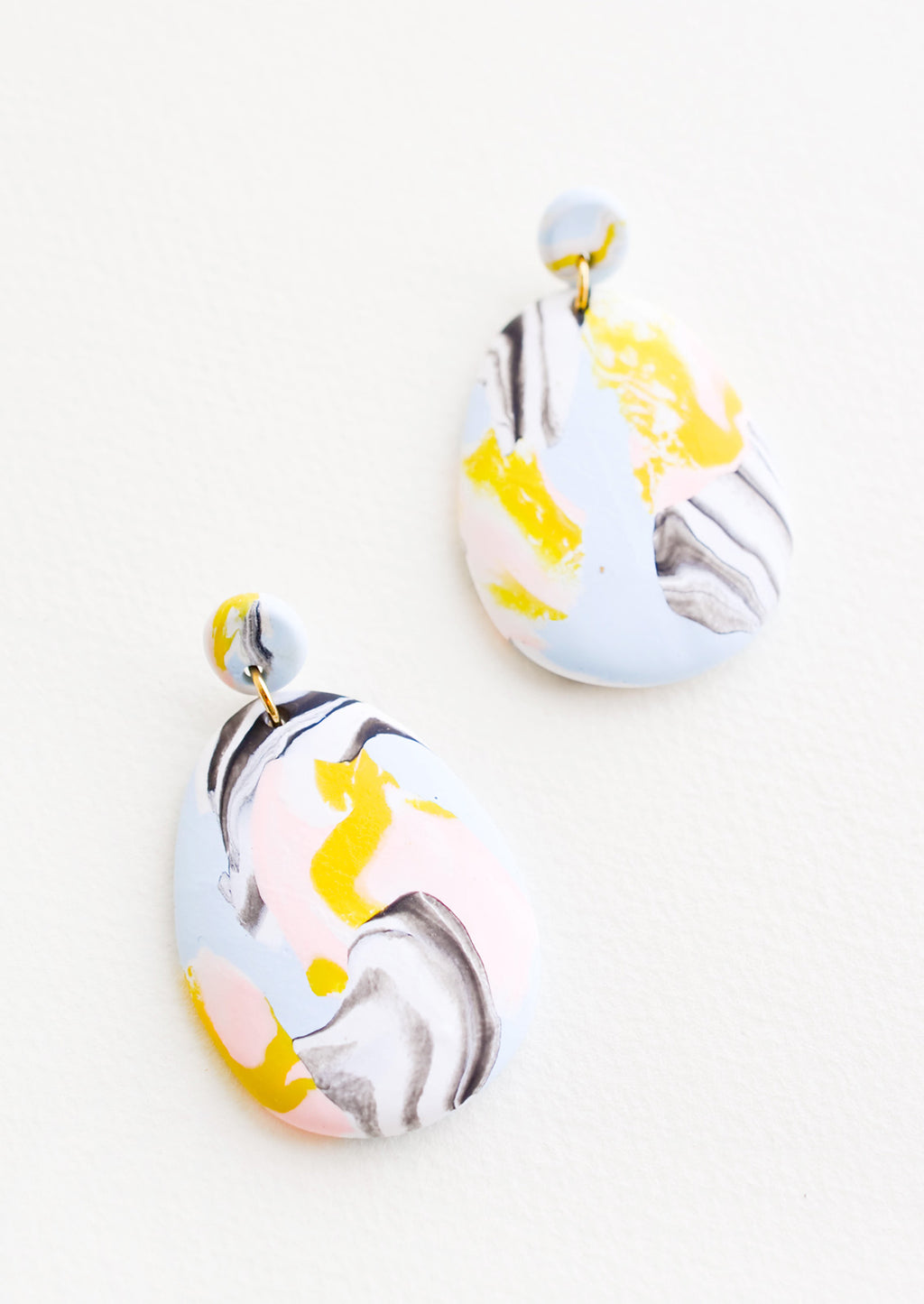 Blue Mist: Blue, pink, yellow, and black marbled clay earrings, with a larger oval dangling from a small circle.