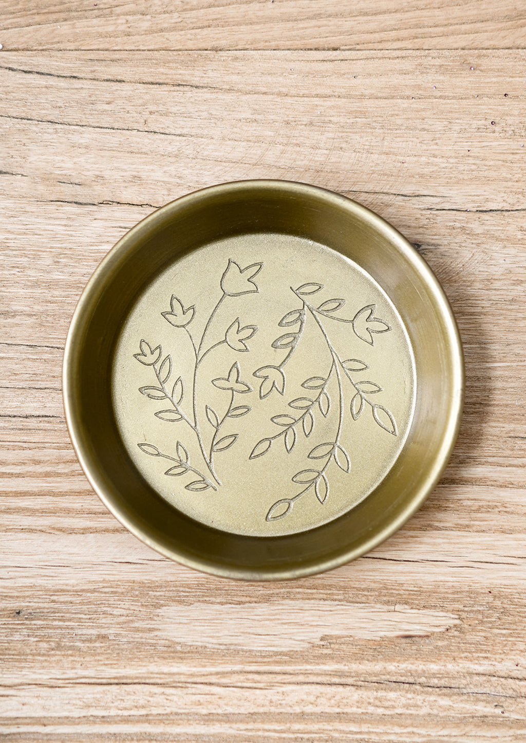 1: A small, round and shallow brass dish with floral engraving.
