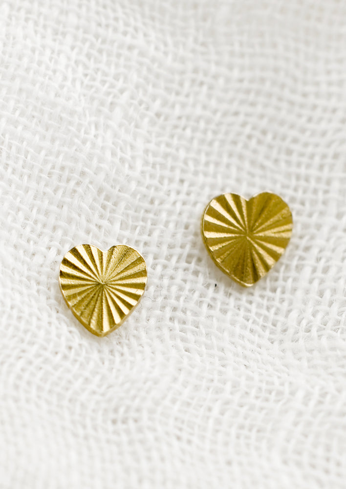 1: A pair of stud earrings in heart shape with radiant etched texture.