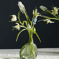 Medium: A tall, asymmetric glass vase in translucent green glass.