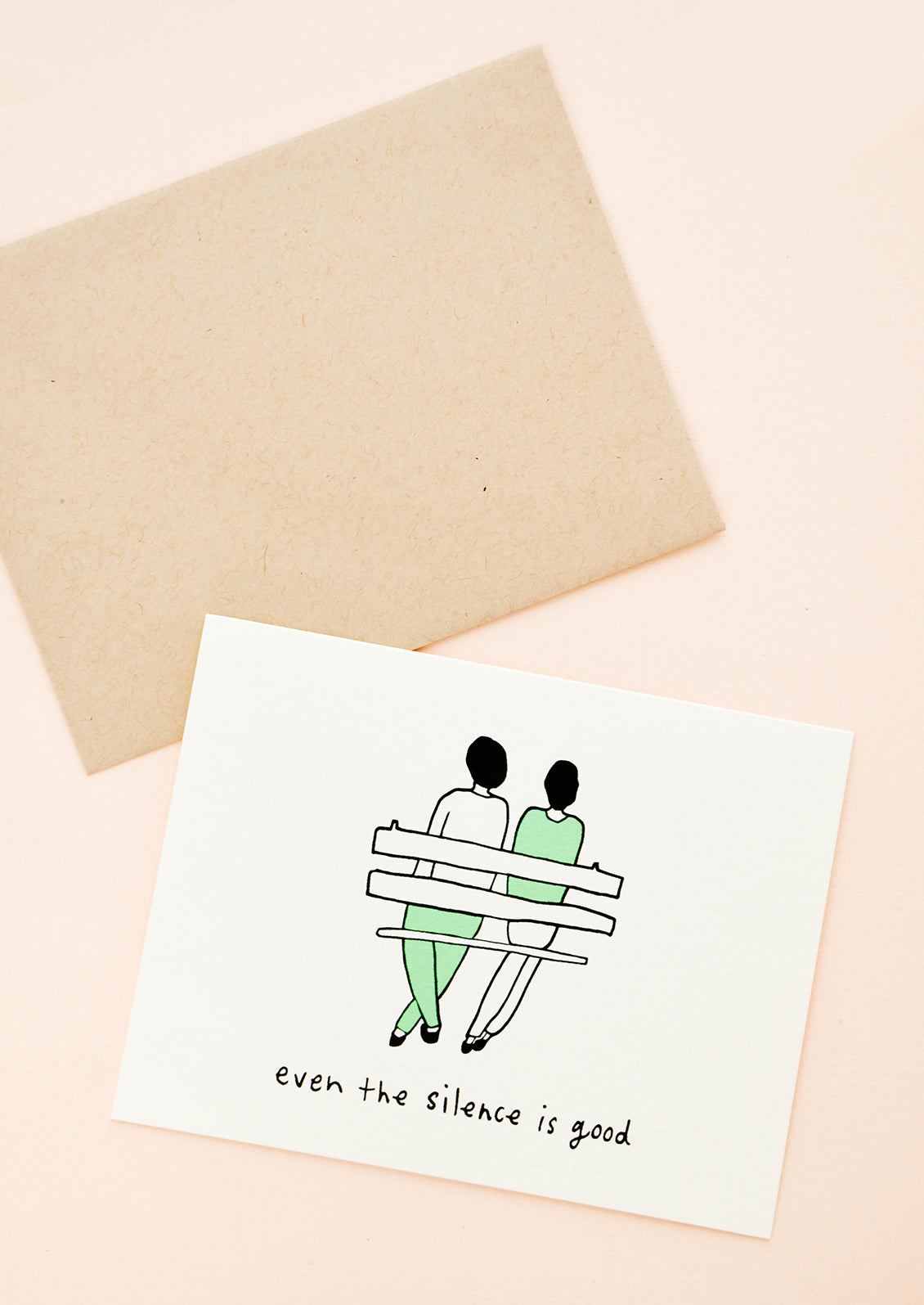 Greeting card with couple sitting on a bench. Text reads "Even the silence is good"