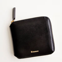 Black: Black leather wallet that zips on three sides, with matching tab pull.