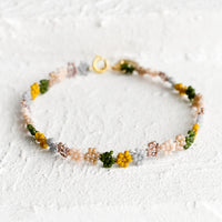 Rosado Multi: A beaded bracelet in flower shape in dusty pink, mustard, grey and olive.
