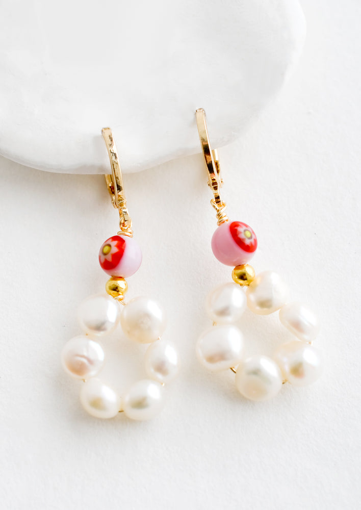 A pair of earrings with pearl flower shape and vintage glass bead detailing.