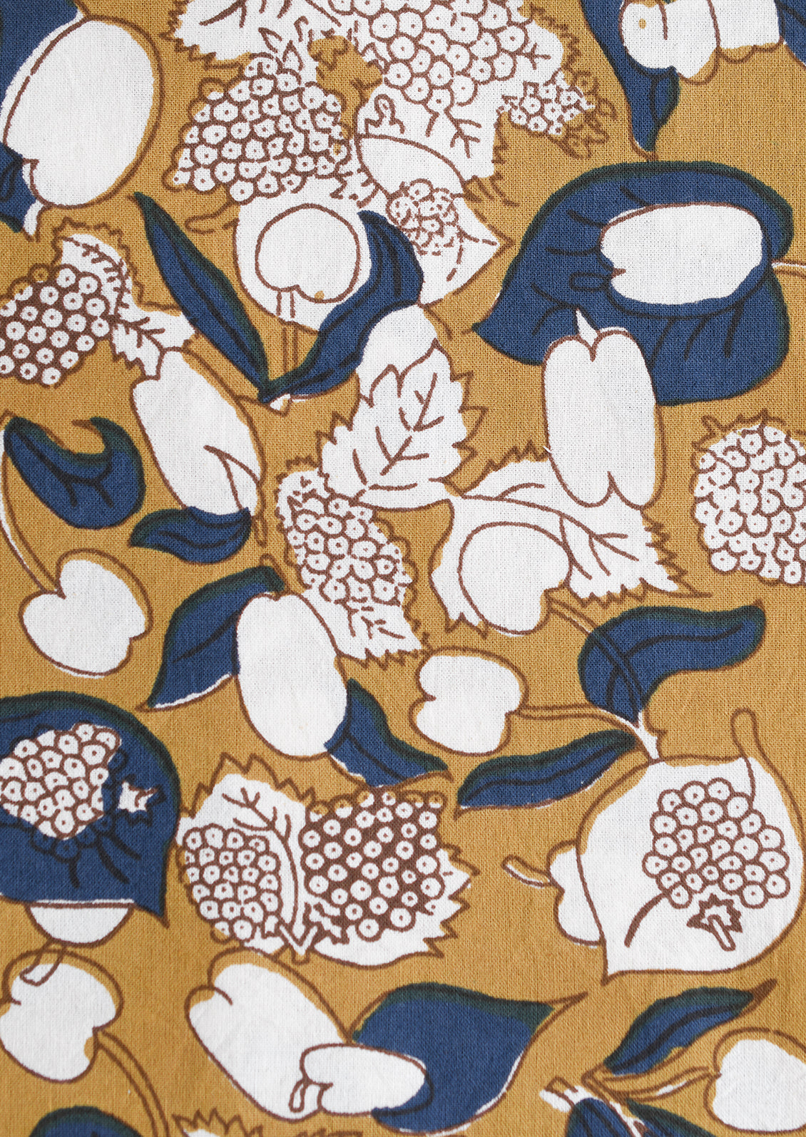 A tablecloth in ochre, navy and chartreuse floral and fruit print.