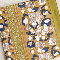1: A tablecloth in ochre, navy and chartreuse floral and fruit print.