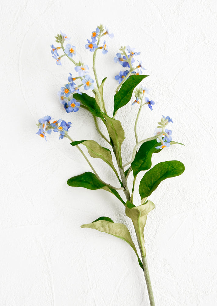 A realistic looking faux flower stem made to look like forget me not.